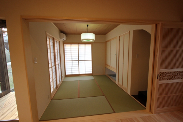 ３枚引込戸で仕切れるリビングからつながった和室。京都の傘屋さんの照明器具、床の間の下の砂利とこだわり満載。  株式会社 イングの施工事例 毎日が楽しくなる家 | 小松市 マイホーム 建築事例