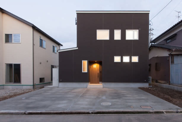 シンプルな外観に木目のドアがアクセントになっている 石川県 金沢市 省エネ住宅・注文住宅|セイダイハウジング ミライロ株式会社（セイダイグループ）の施工事例 家族みんなで床塗装に挑戦！アンティークインテリアの家