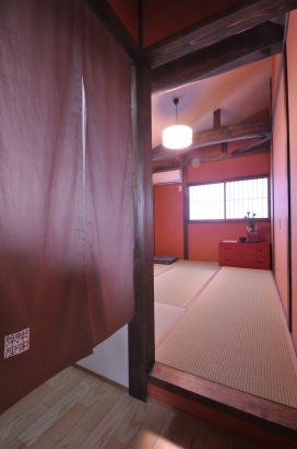 こあがり寝室の上空には、丸太と朱色の和紙襖の壁が趣を感じます。