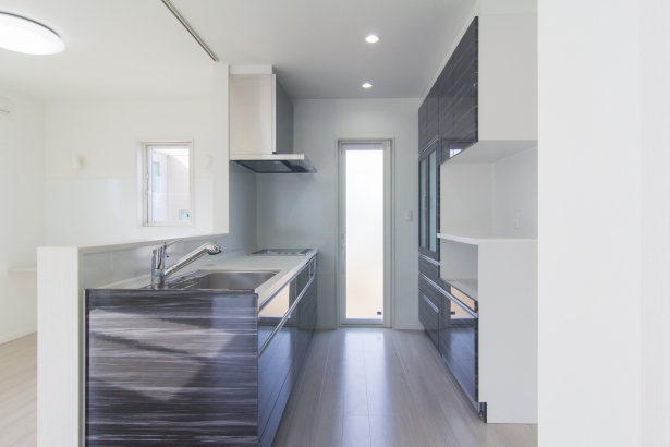 キッチン 葵建設株式会社の施工事例 真っ白な空間にブラックのキッチンがある家