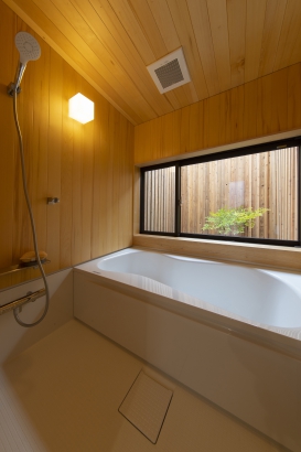 ヒノキ張りのハーフユニットバス。坪庭を眺めながら入浴を楽しめます。 株式会社　HAUSの施工事例 二枚の壁をつむぐ家