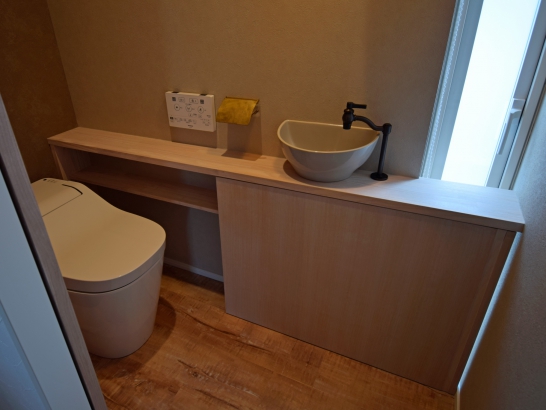 収納と手洗いカウンターを備えたトイレ 有限会社 吉田建築の施工事例 個性が光る、家事がしやすい住まい