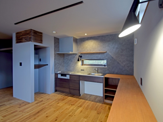 部屋のテイストに合わせたシステムキッチン 有限会社 吉田建築の施工事例 「SE構法」で実現する、光とプライバシーを両立させた2世帯住宅のいえ